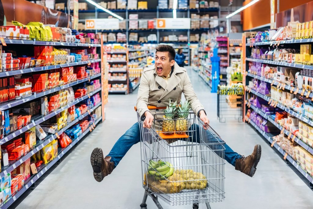 A man jumps in the air as he goes grocery shopping.
