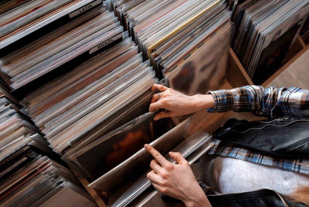 A woman sorts through a vinyl collection. 