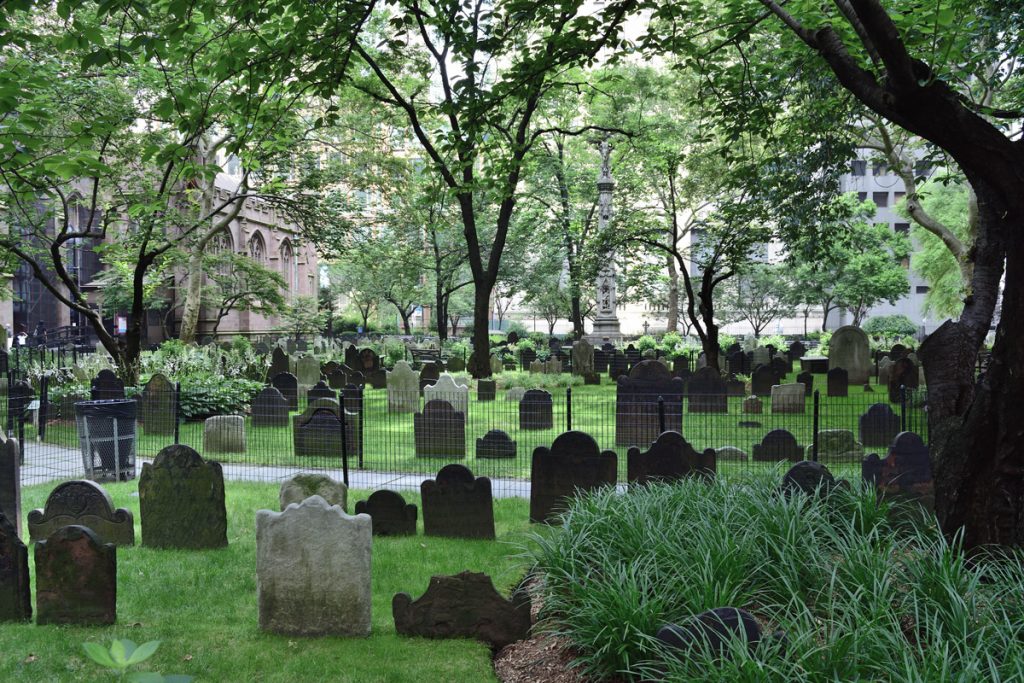 Gravestones are shown among trees and bushes at the Trinity cemetery in New York City. 