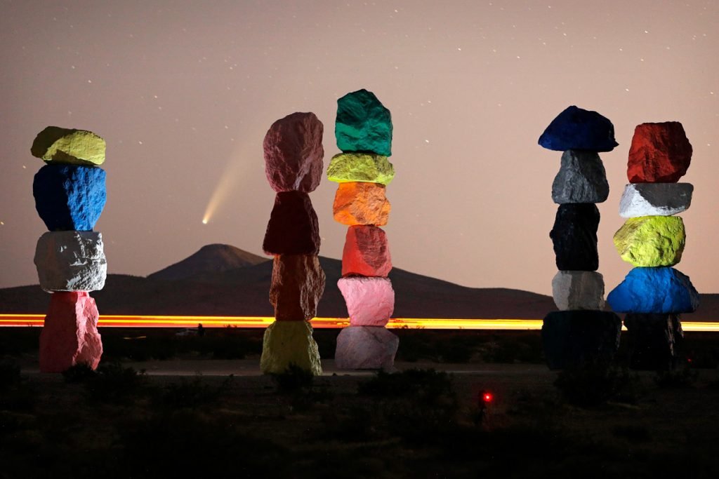A comet is seen in the distance from the location of Seven Magic Mountains in Nevada.
