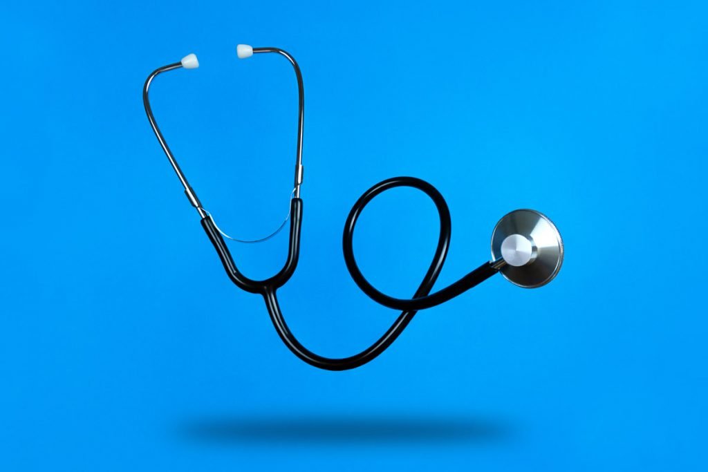 A stethoscope is photographed against a blue background. 