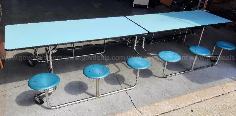 A photo of cafeteria tables that are light blue. 