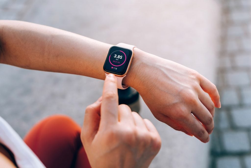 A woman wears a smart watch while working out.
