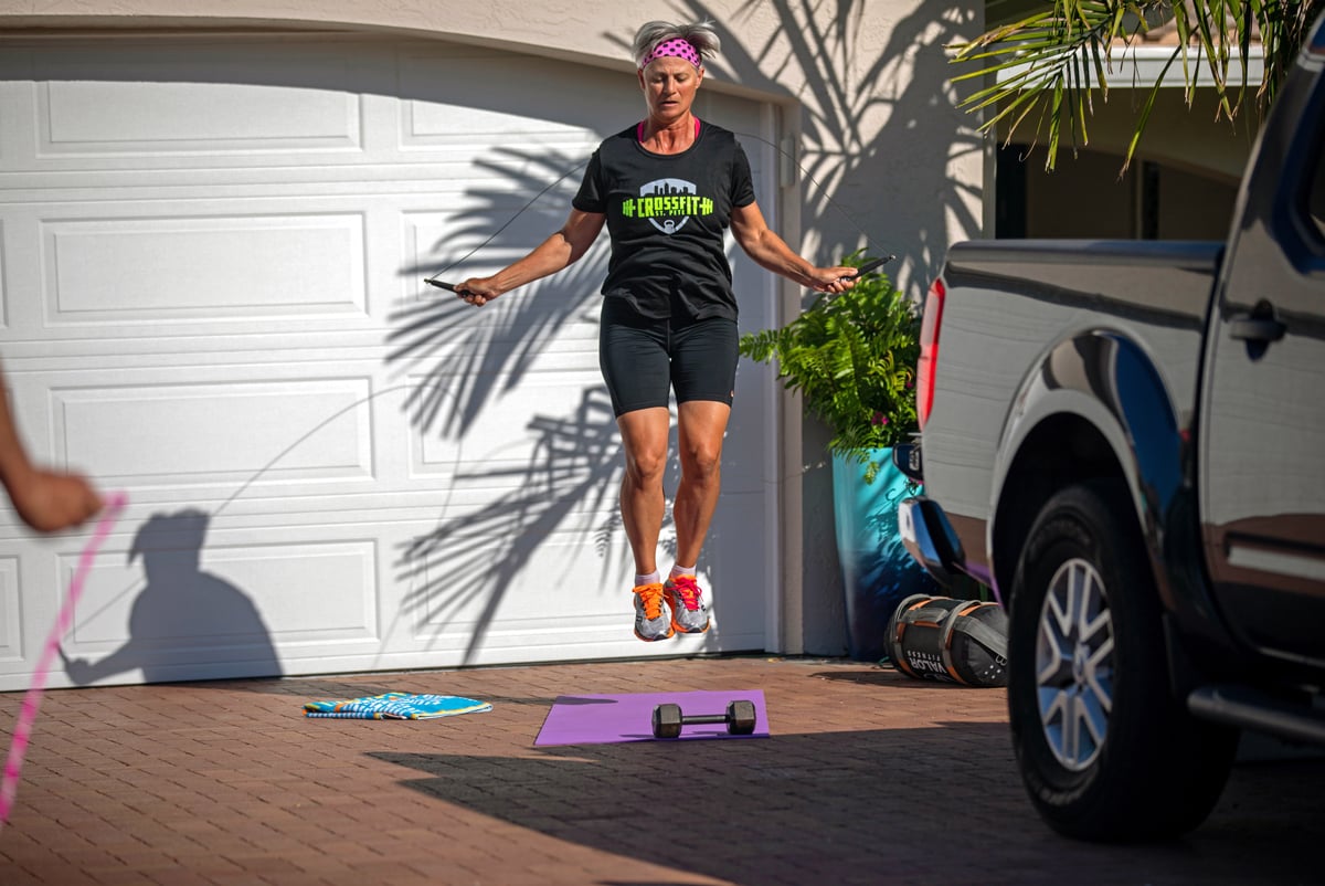 A woman jump ropes during a virtual fitness class. 
