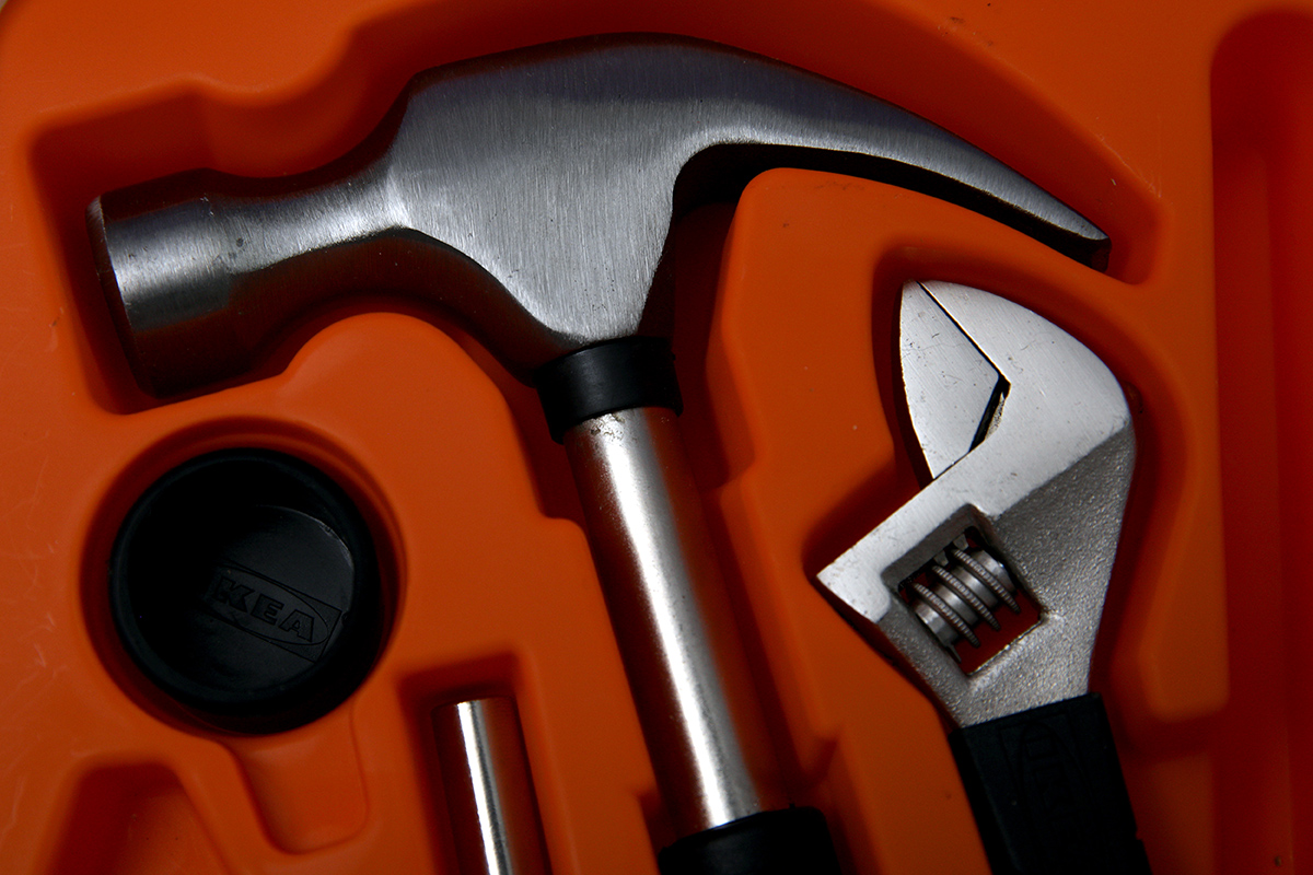 A tight photo of a hammer is shown against an orange background.