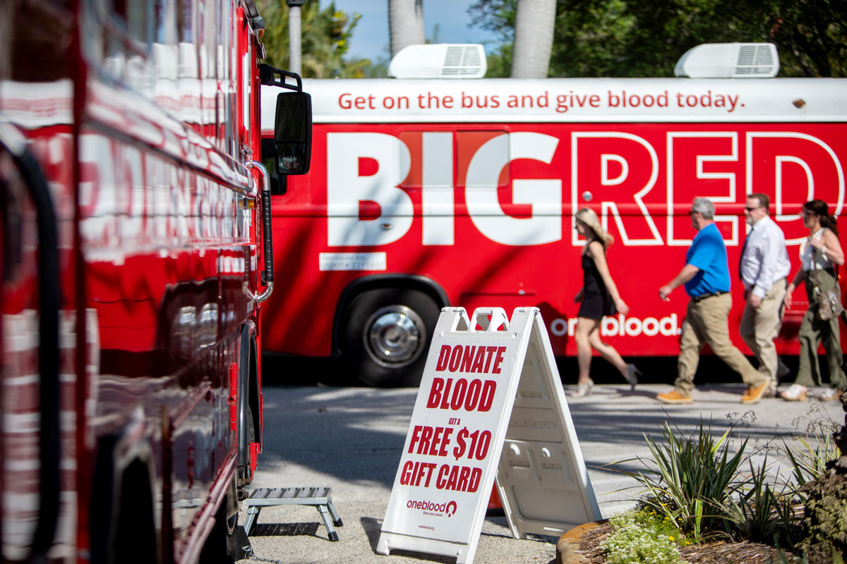 People line up at a blood donation bus to donate blood. 
