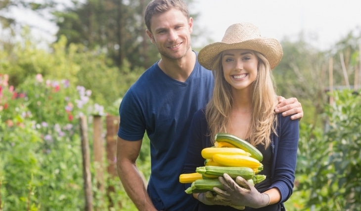 Happy couple holding home grown crops