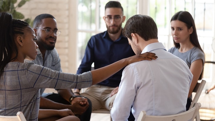 Group encouraging a depressed man